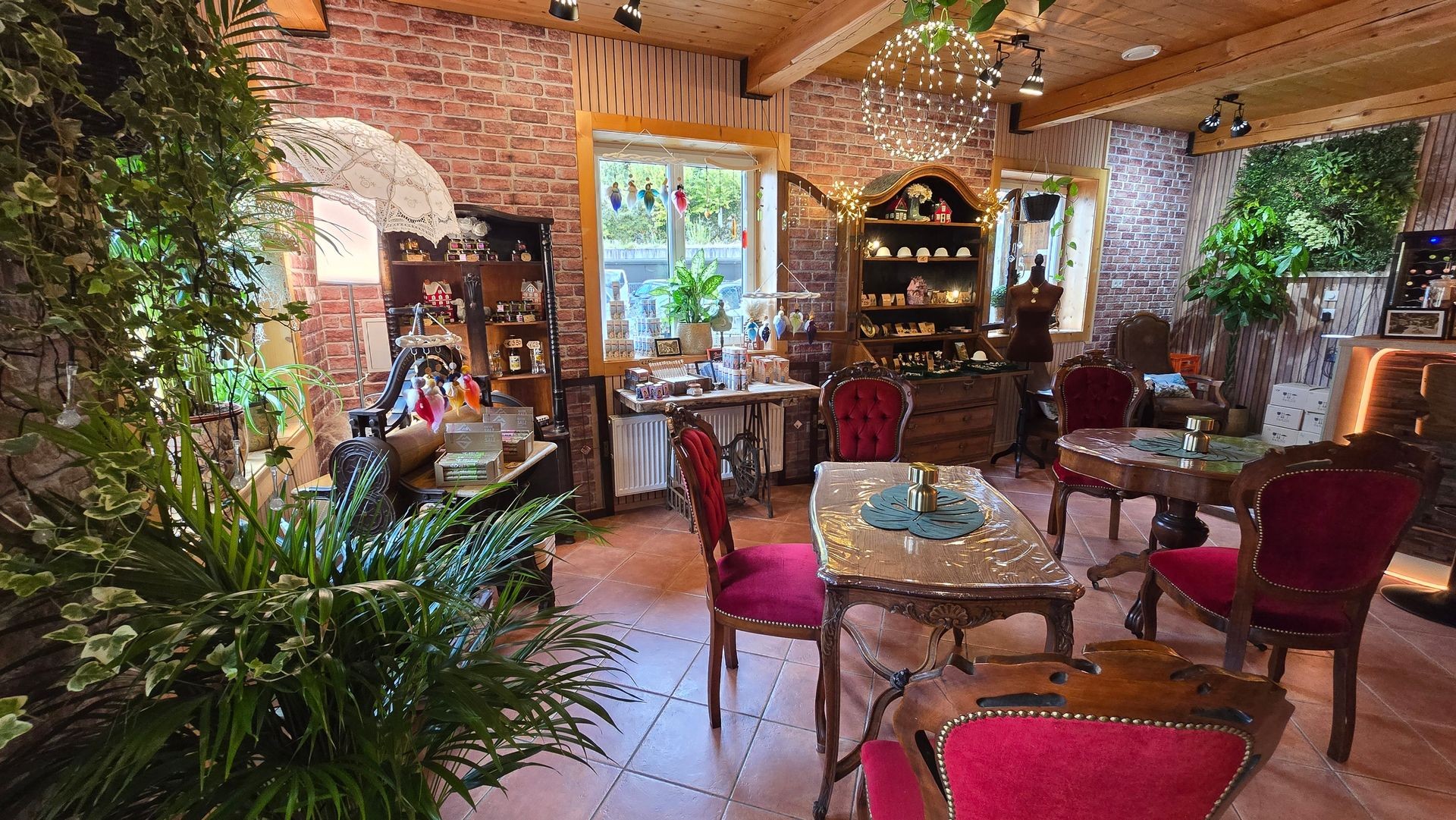 Cozy cafe interior with vintage furniture, plants, and decorative shelves on a brick wall backdrop.
