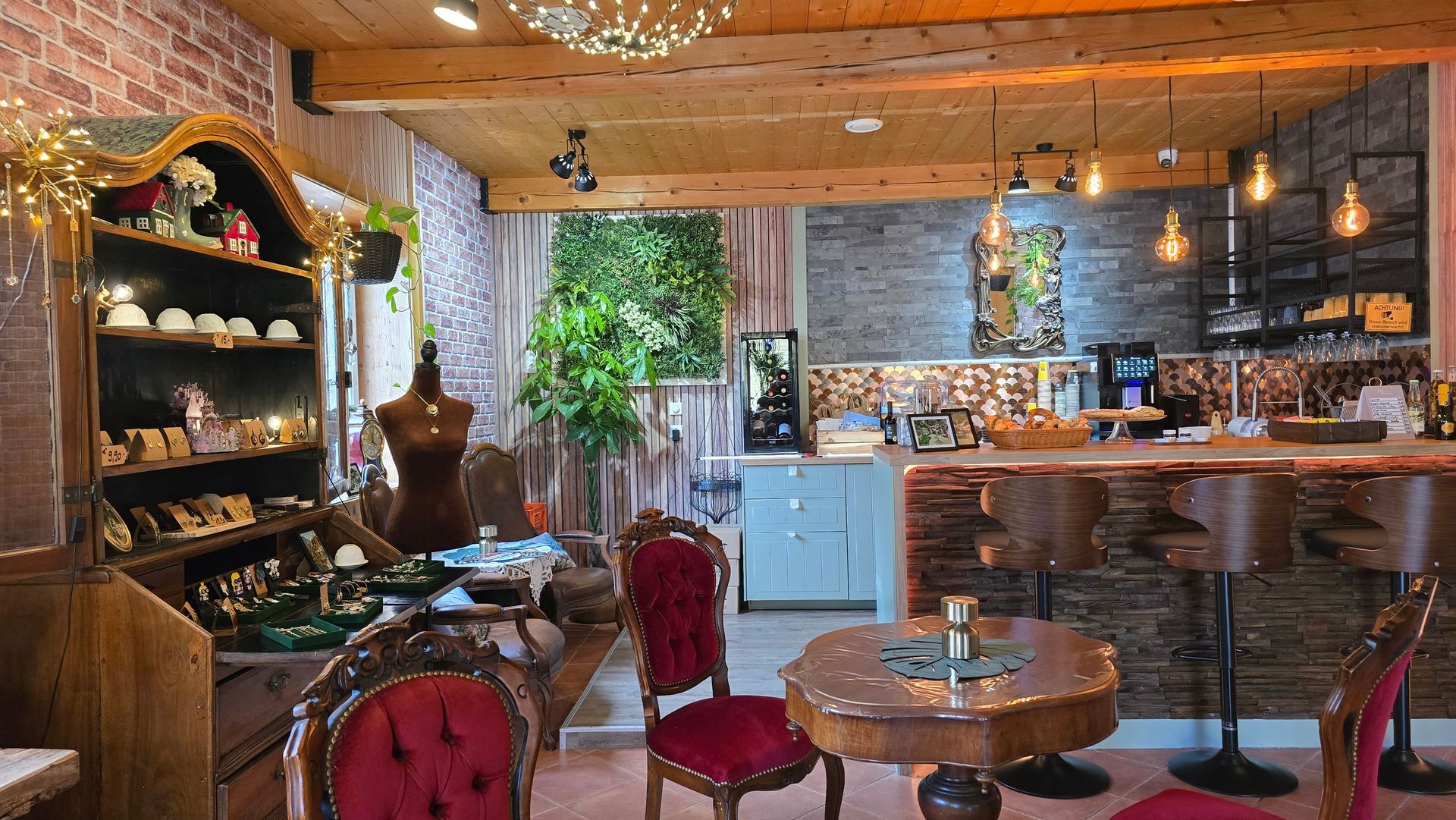 Cozy cafe interior with wooden furniture, decorative shelves, a bar counter, and hanging lights.